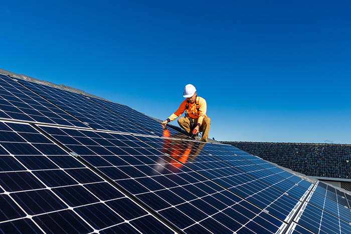 Technicien mettant la touche finale à l'installation d'un panneau solaire