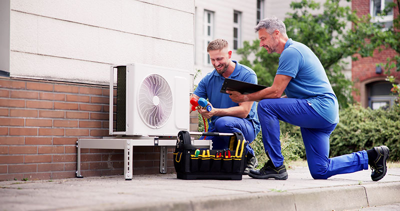 Technicien effectuant la maintenance d'une pompe à chaleur réversible